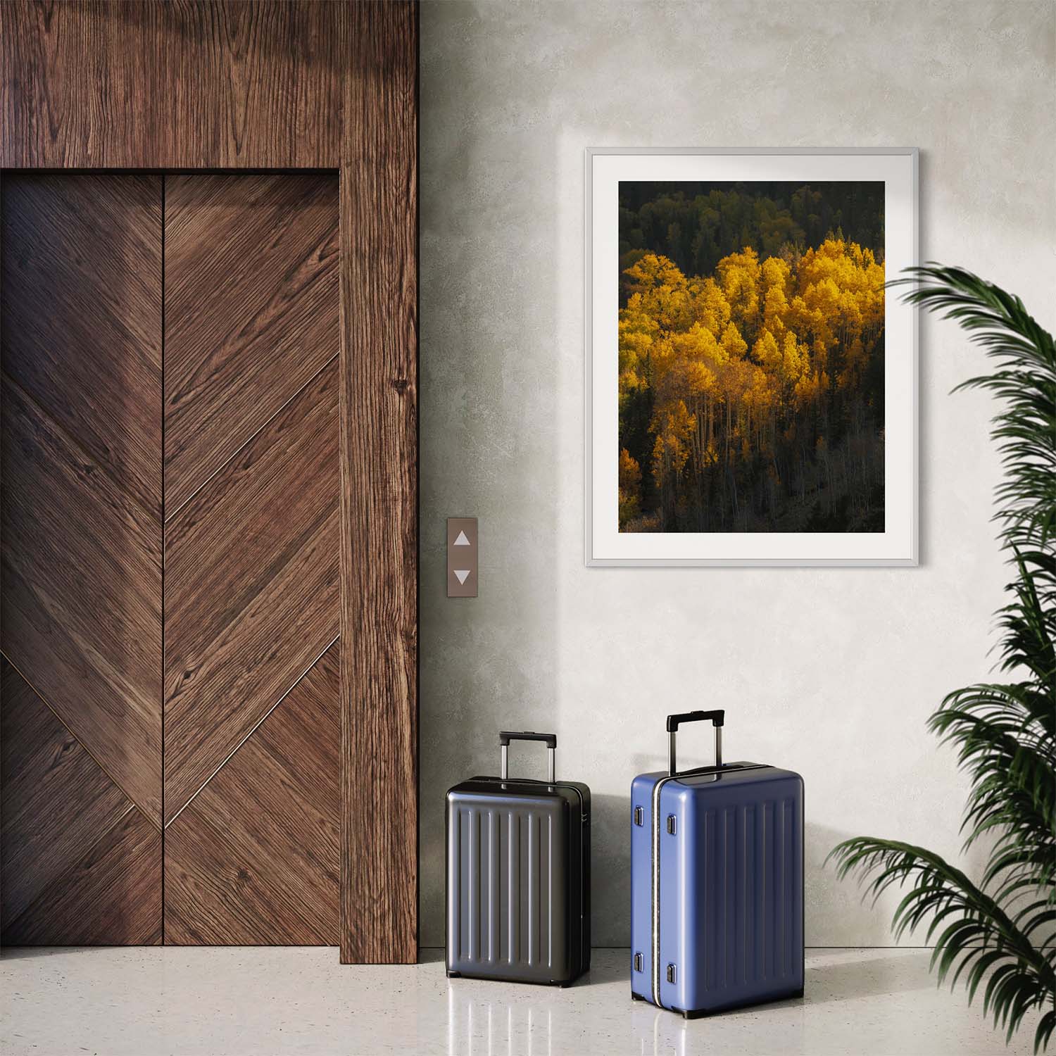 A framed photograph of yellow aspen trees during autumn season hangs on the wall next to an elevator in a white frame.