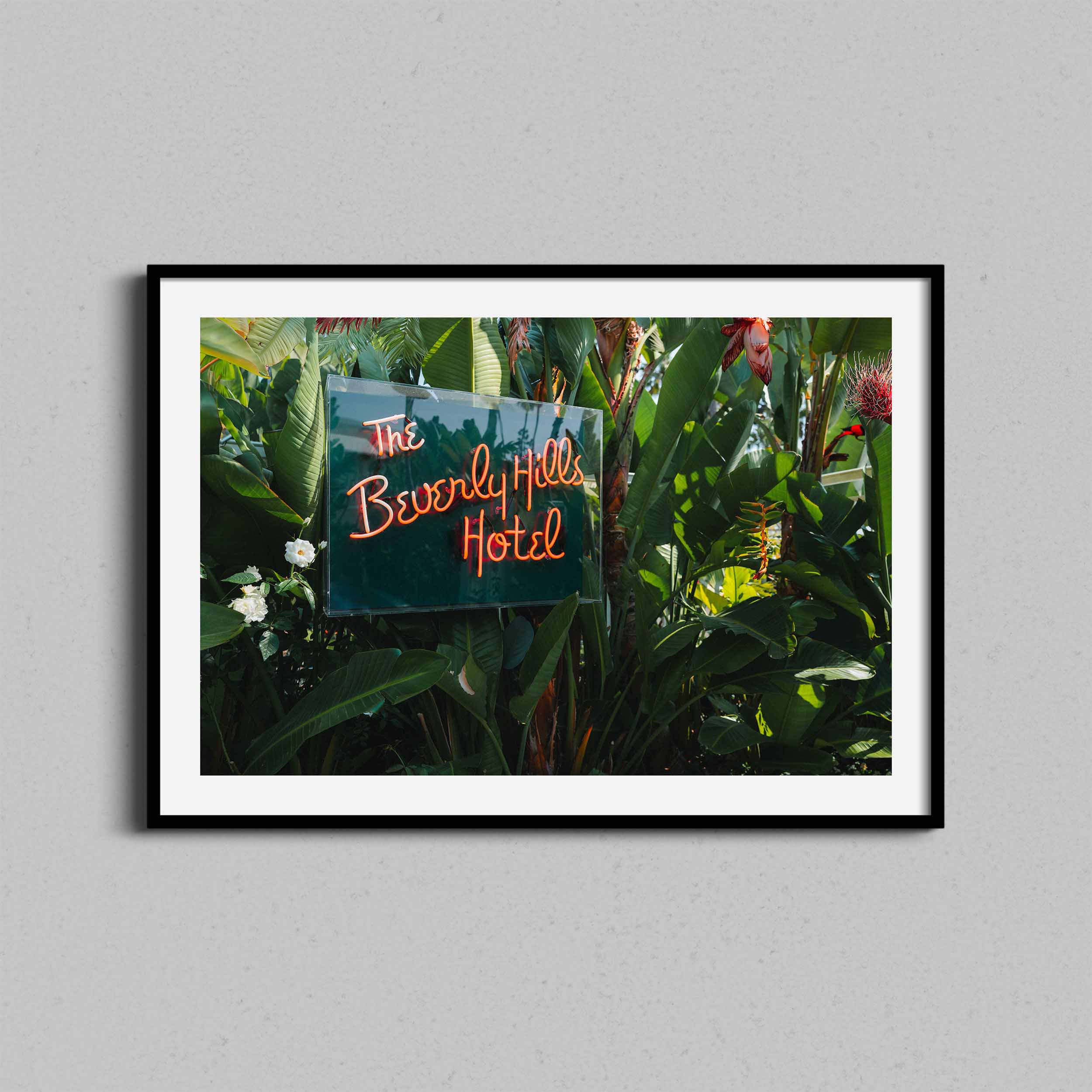 A fine art photograph of the Beverly Hills Hotel neon signed framed in a black wooden frame.