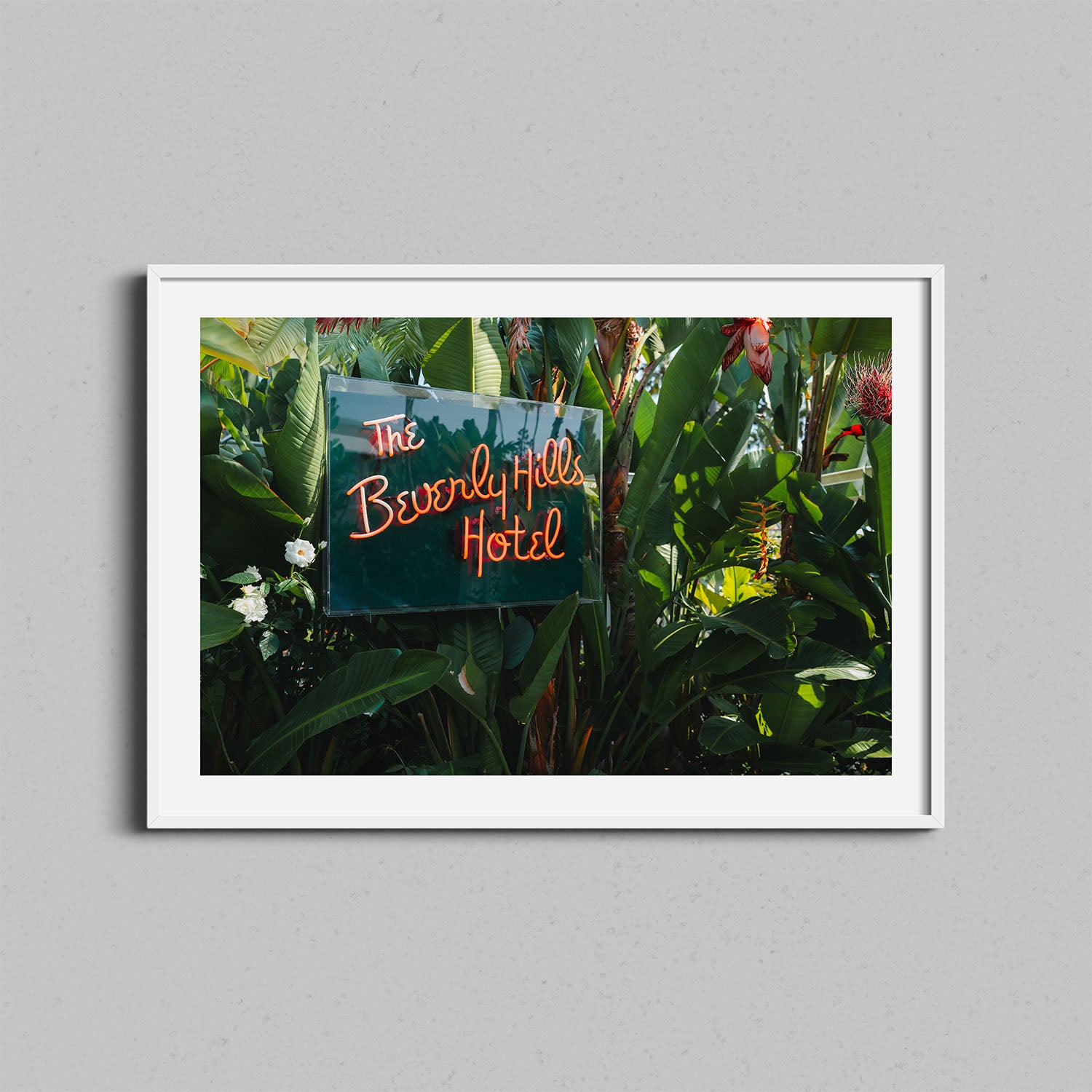A fine art photograph of the Beverly Hills Hotel neon signed framed in a white wooden frame.