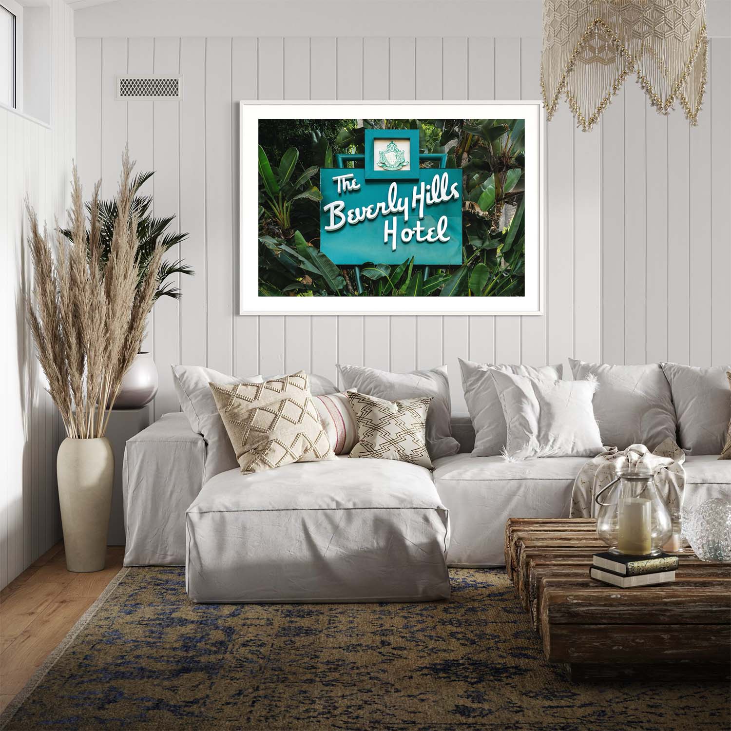 A photograph of the Beverly Hills Hotel entrance sign hangs on the wall in a coastal themed living room.