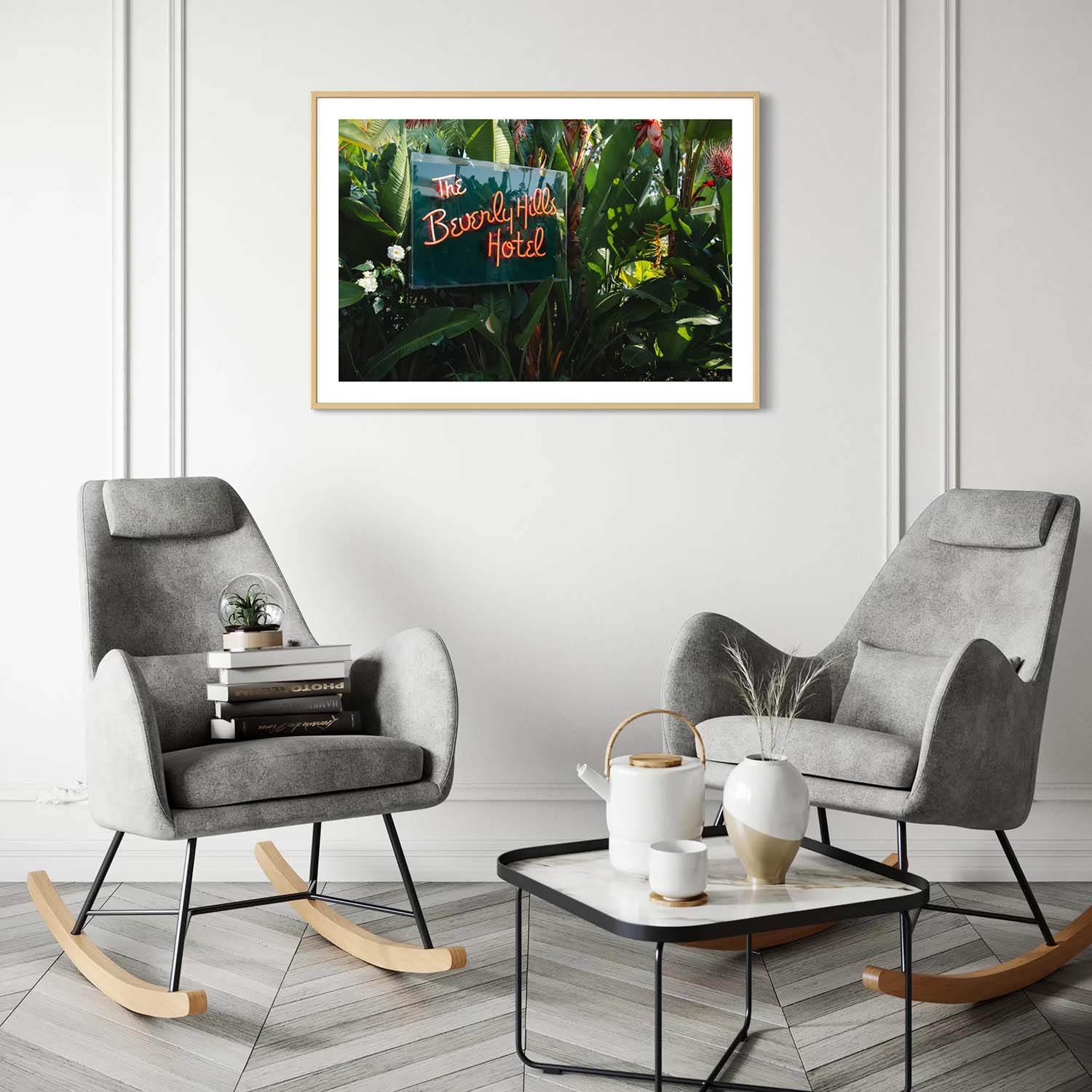 A fine art photography print of the neon sign from the entrance to the Beverly Hills Hotel hangs on the wall in a mid-century modern living room.