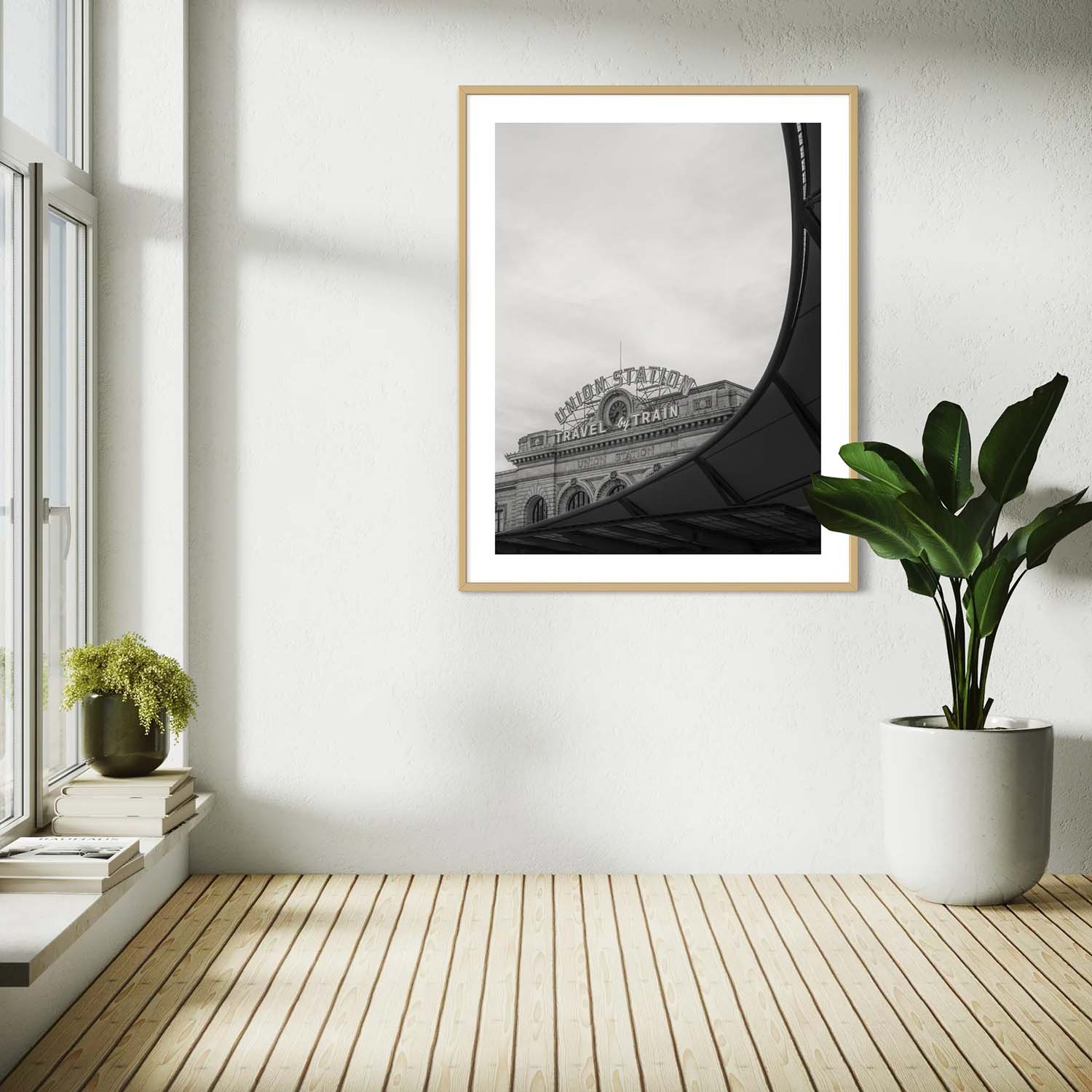 A black and white photography print of Denver's Union Station on a wall in a mid-century modern reading nook.