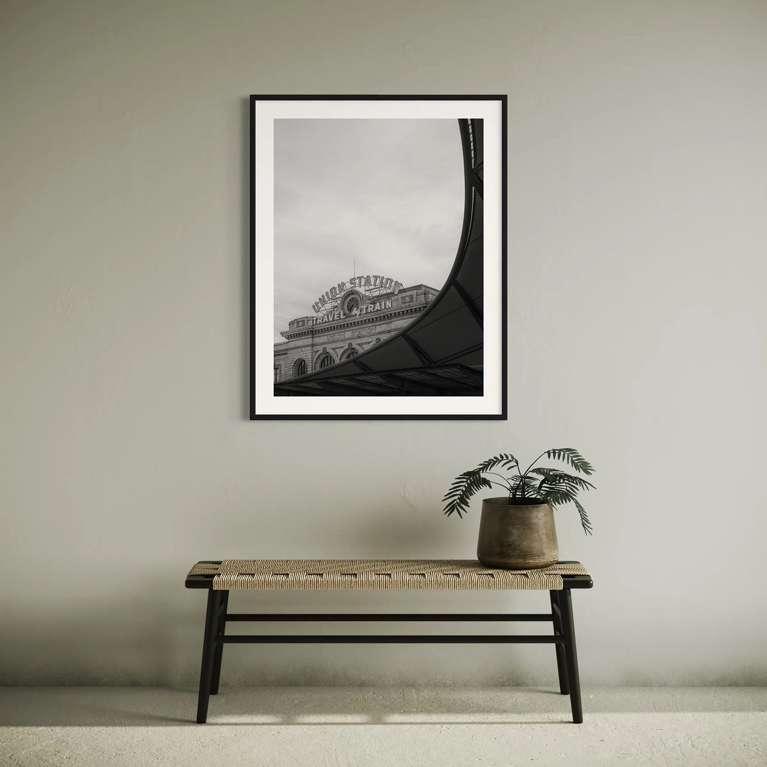 A black and white photography print of Denver's Union Station on a wall in a mid-century modern entryway.