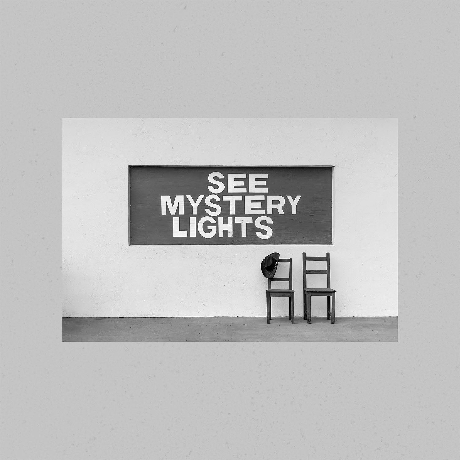 A black and white photography print of the See Mystery Lights sign in Marfa, Texas with no frame.