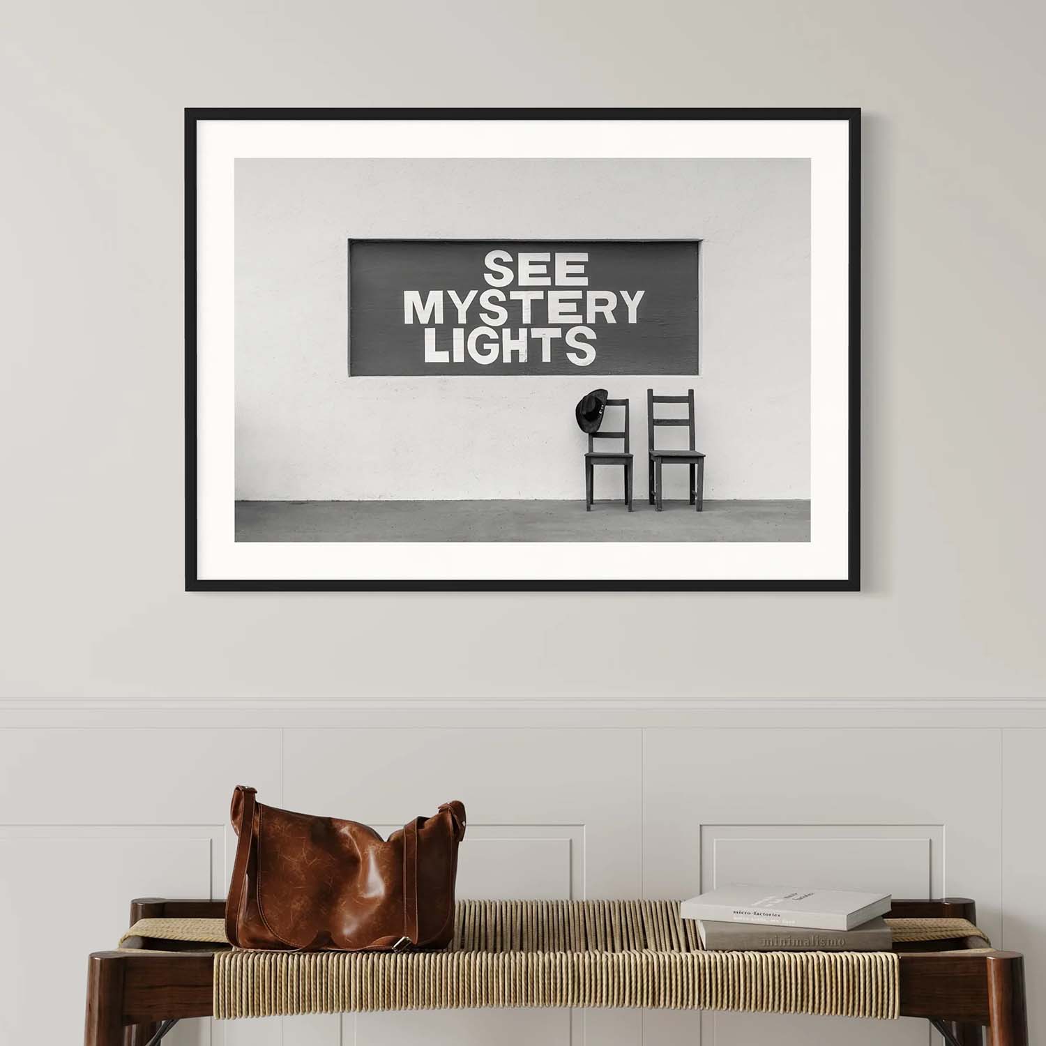 A black and white photography print of Marfa, Texas' See Mystery Lights sign hanging in a southwestern-inspired entryway.