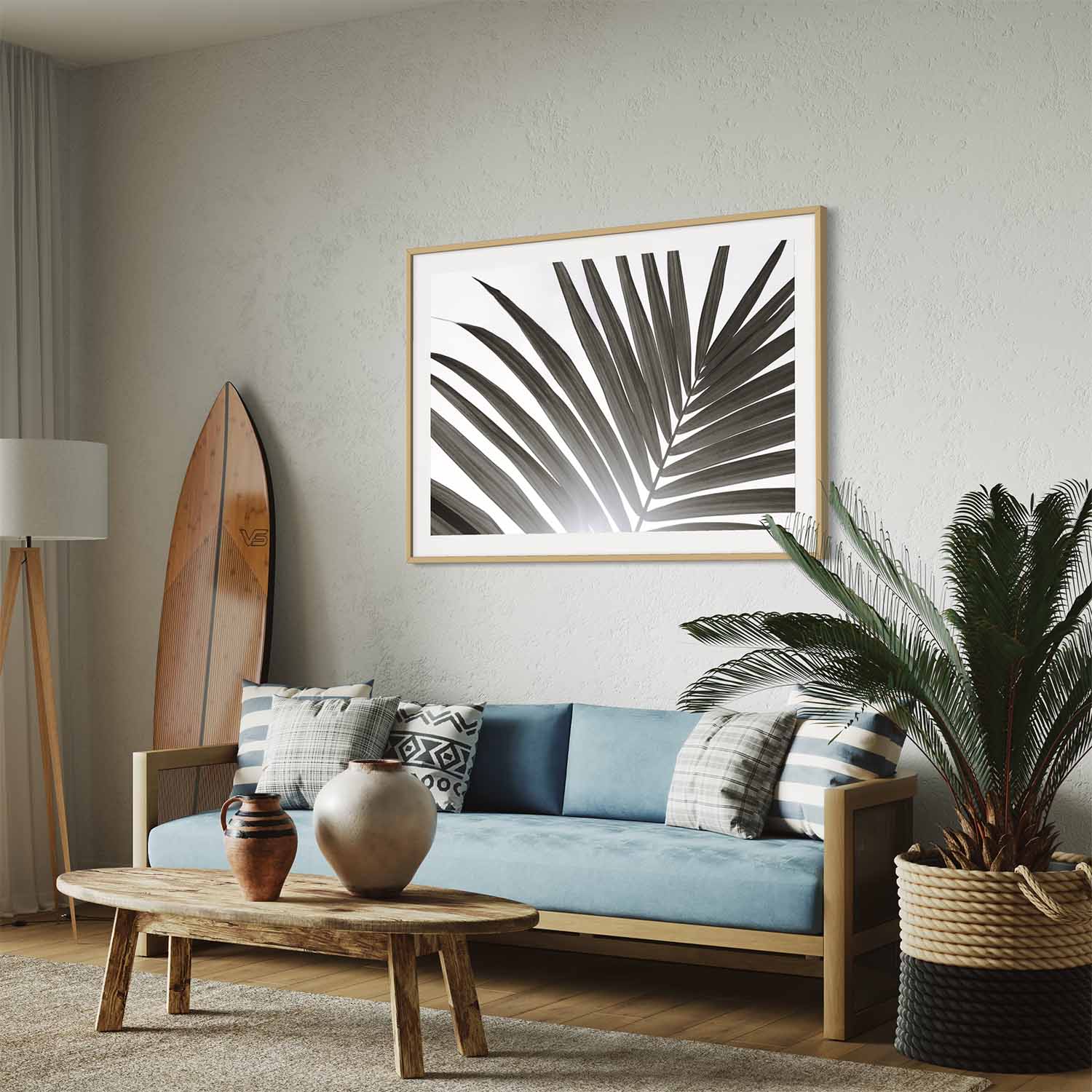 A framed photograph of a palm tree leaf hangs on a wall in a coastal-themed living room.