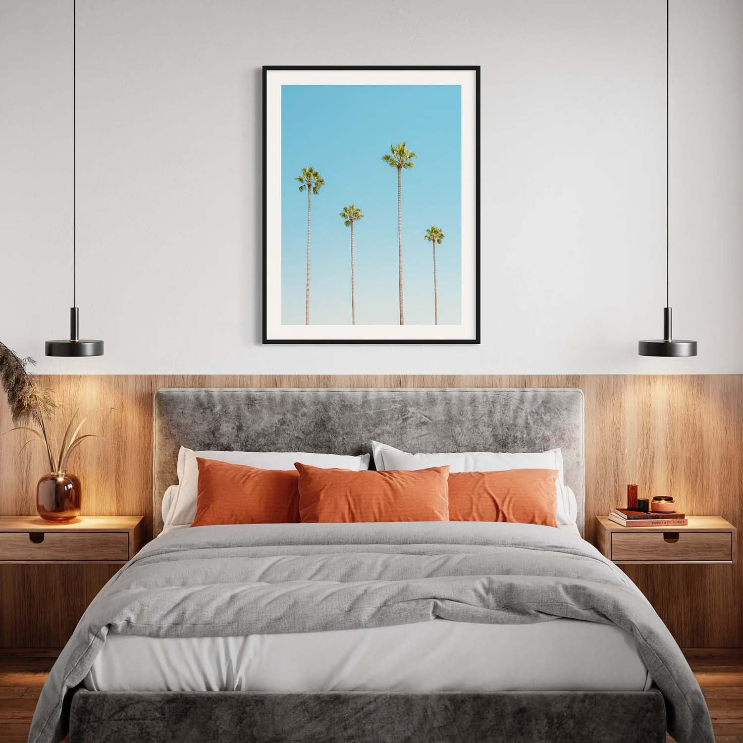A framed photo of four palm trees hangs over a bed in a mid-century modern bedroom.