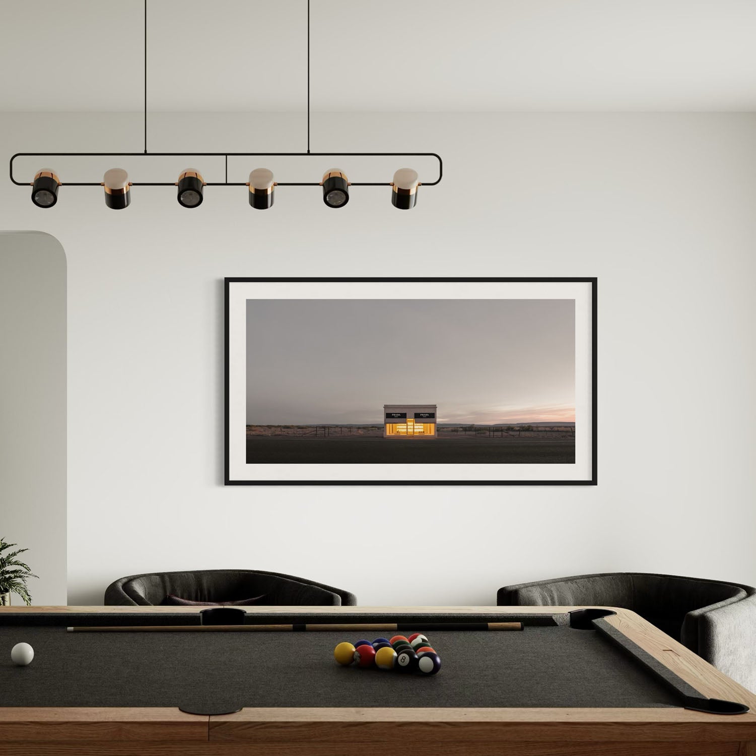 A panoramic photo of the Prada Marfa store hangs on the wall over a pool table.