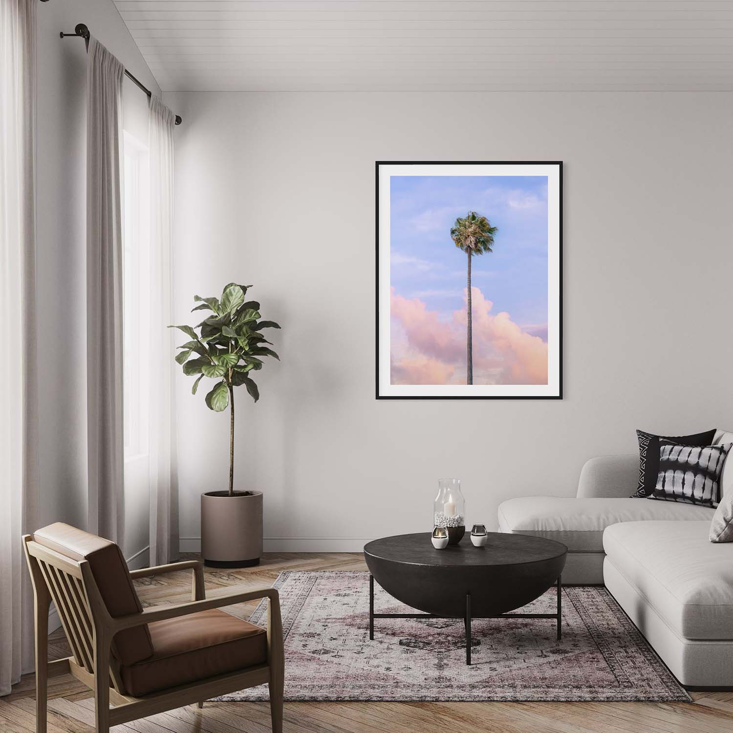 A framed photograph of a single palm tree against a sunset sky hanging on a wall in a contemporary living room.