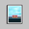 A photograph of the Prada Marfa art installation framed with a black wooden frame.