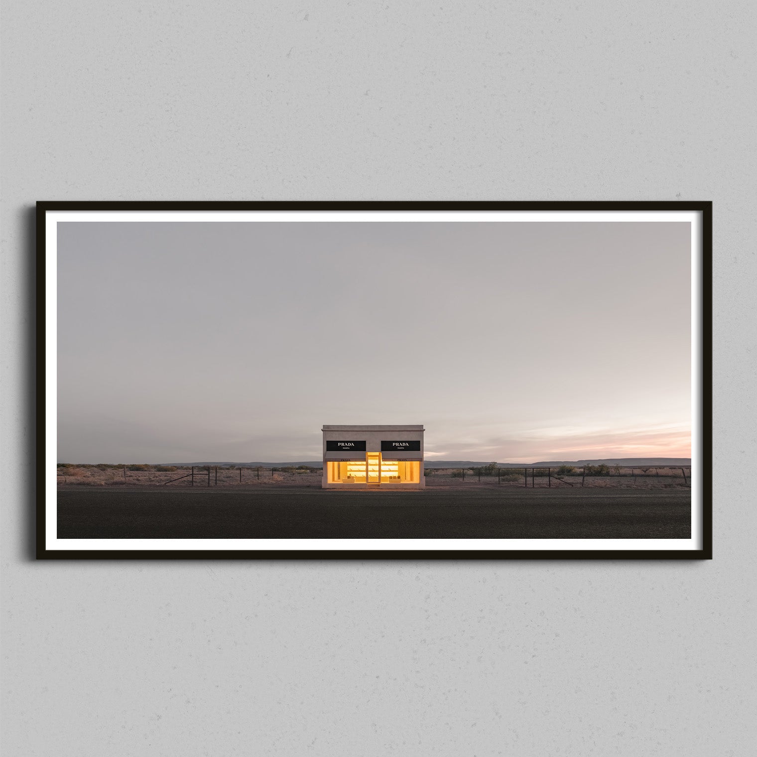 A panoramic photo of the Prada Marfa store framed in a black wooden frame.